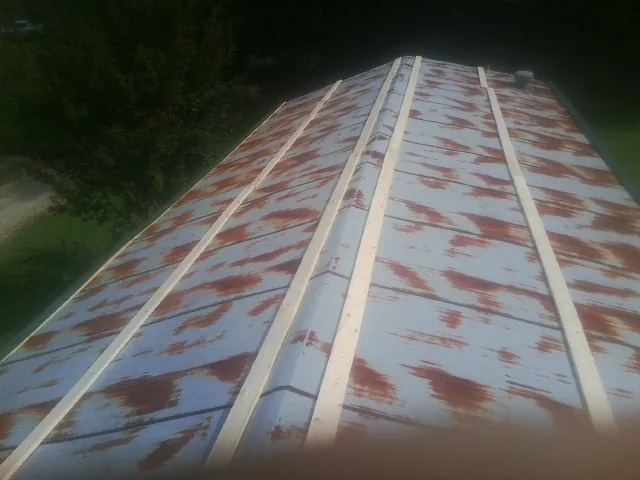 Rusted metal roof panels with new wood purlins before replacement — Storm Damage Roof Repair in Crofton by Roofing Brothers