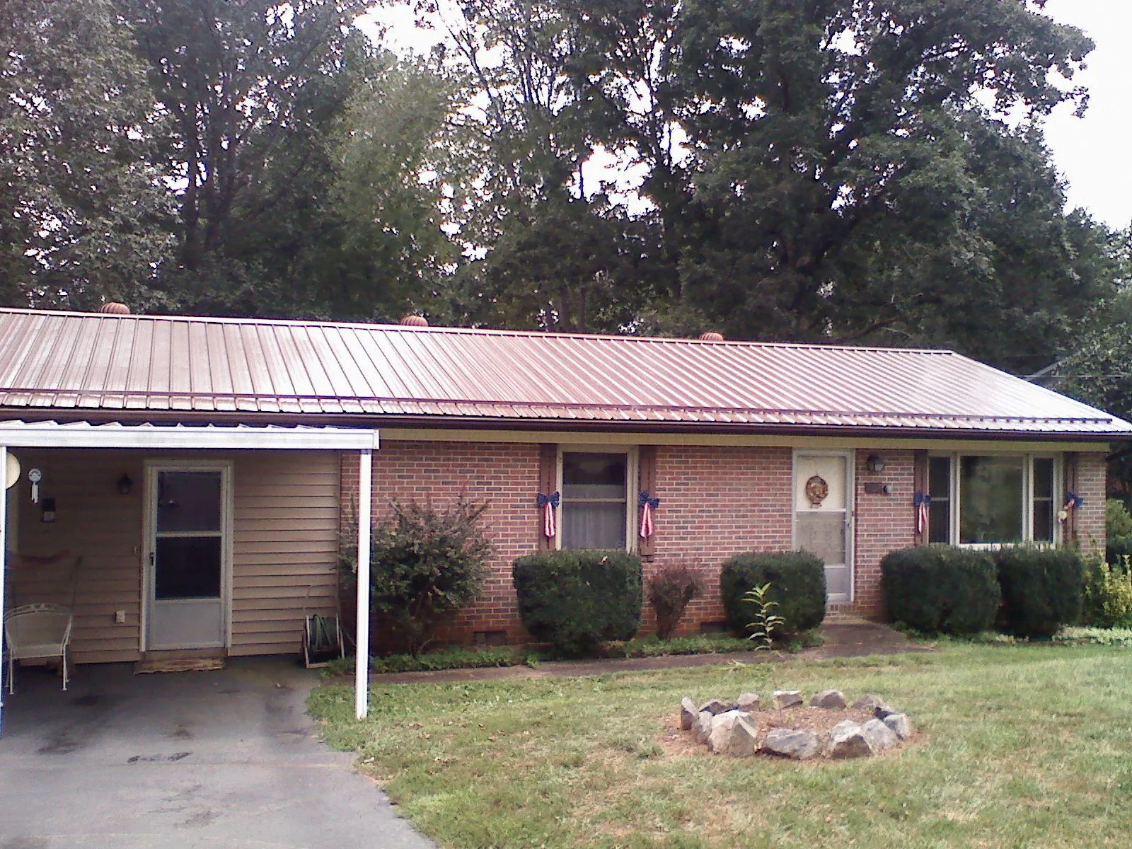 Bronze metal roof and carport on a brick ranch home — Roof Repair work by our crew in Crofton